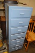 A narrow blue painted seven drawer chest