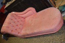 A pink upholstered chaise longue
