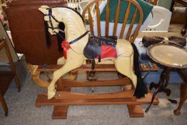 A rocking horse with black mane and brown and red saddle