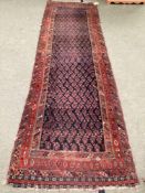 Small Persian style rug runner, with blue and red and all over geometric design, with central