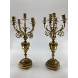 Pair of C19th gilt brass five branch table candelabras, on circular stepped bases, with goats head