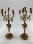 Pair of C19th gilt brass five branch table candelabras, on circular stepped bases, with goats head