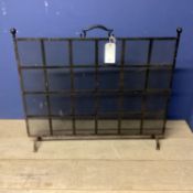 A black metal fire screen, with square lattice pattern, 86cmH x 102cmW