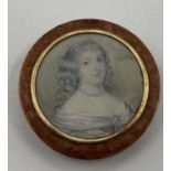 A circular walnut table snuff box, the cover set with a portrait of an C18th lady with yellow