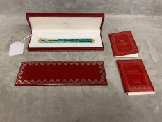 A Must de Cartier gold plated and faux malachite ball point pen, box and papers