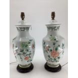 A pair of Chinese style table lamps, white ground and green and pink foliage, on stands, 49cm H