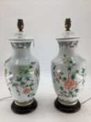 A pair of Chinese style table lamps, white ground and green and pink foliage, on stands, 49cm H
