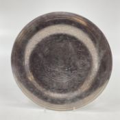 A white metal Cairo ware charger with chased decoration, 34.5cm diam