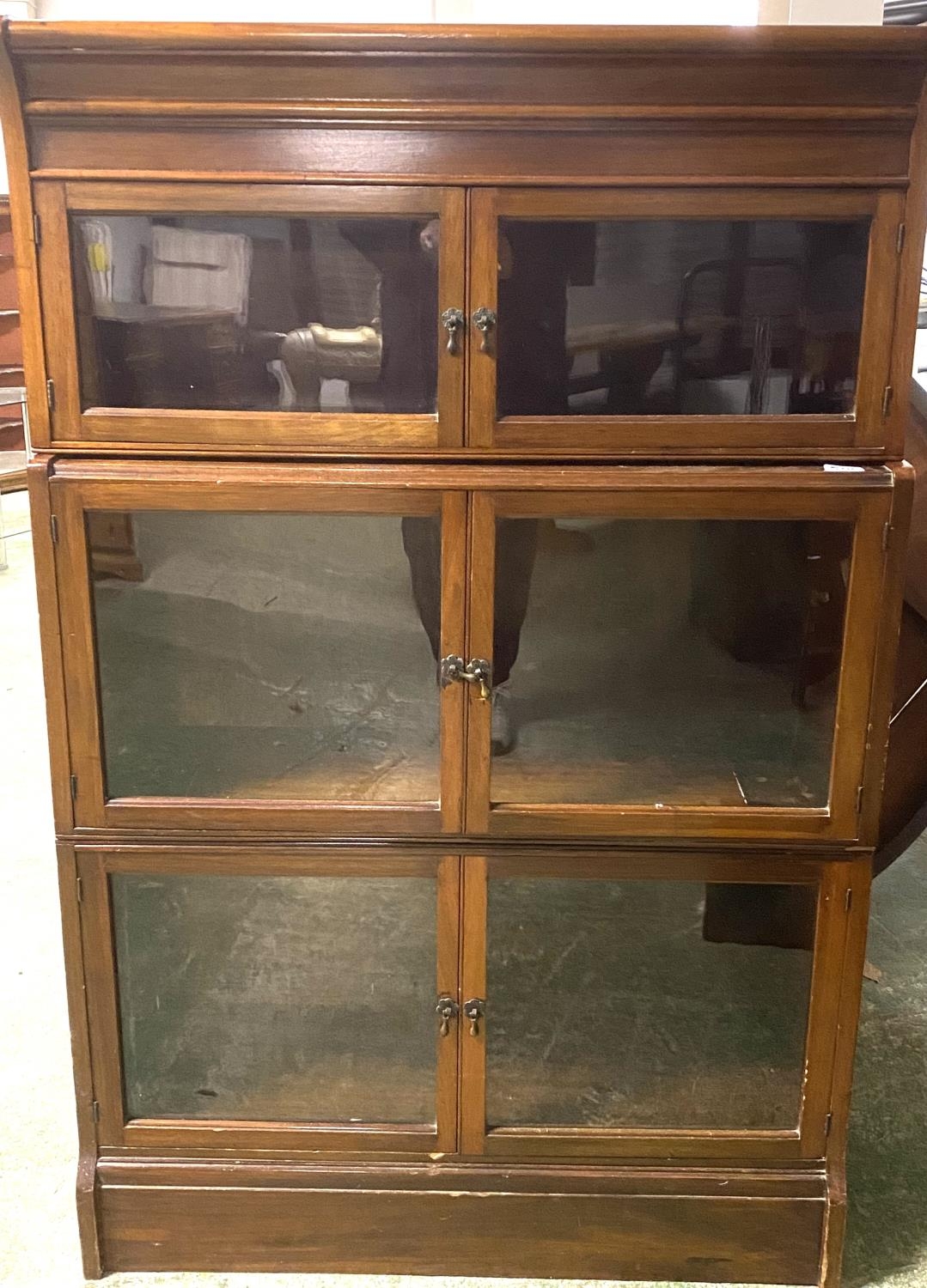 A Globe Werneke style three tier glazed narrow book case with glazed doors 132Hx 85W x 28D