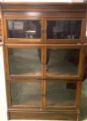 A Globe Werneke style three tier glazed narrow book case with glazed doors 132Hx 85W x 28D