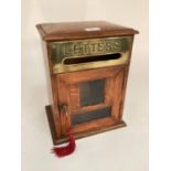An early C20th letter or post box of oak construction with brass plate and bevelled glass single