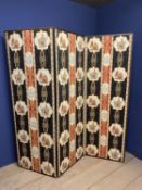 A three panelled folding upholstered screen, the front with a red and black pattern depicting