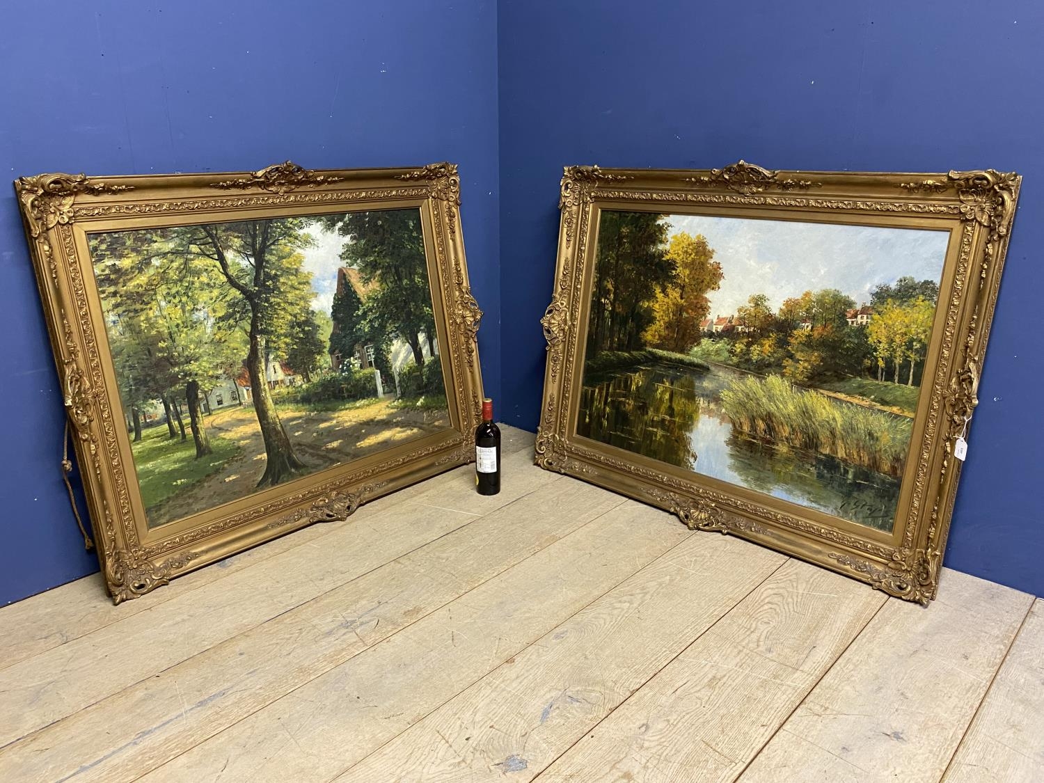 Two gilt framed large oil on canvas of village and river scenes, both approx 71 x 98cm