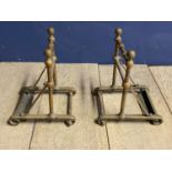 A pair of brass, Arts & Crafts style geometric shaped fire dogs, 26cmH