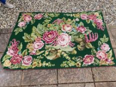 A tapestry rug, with green ground and pink roses