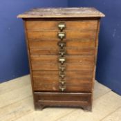 A Vintage narrow filing chest of 9 drawers, bearing label to bottom section: Percy Jones Ltd,