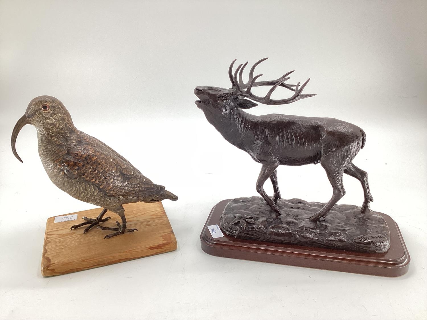 A modern decorative bronze style model of a red stag, mounted on wooden plinth, 27cm H x 30cm W