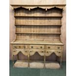 A large pine dresser, the base with 3 drawers and 6 small spice drawers, above a shaped frieze,