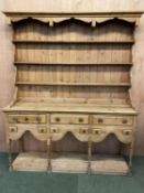 A large pine dresser, the base with 3 drawers and 6 small spice drawers, above a shaped frieze,