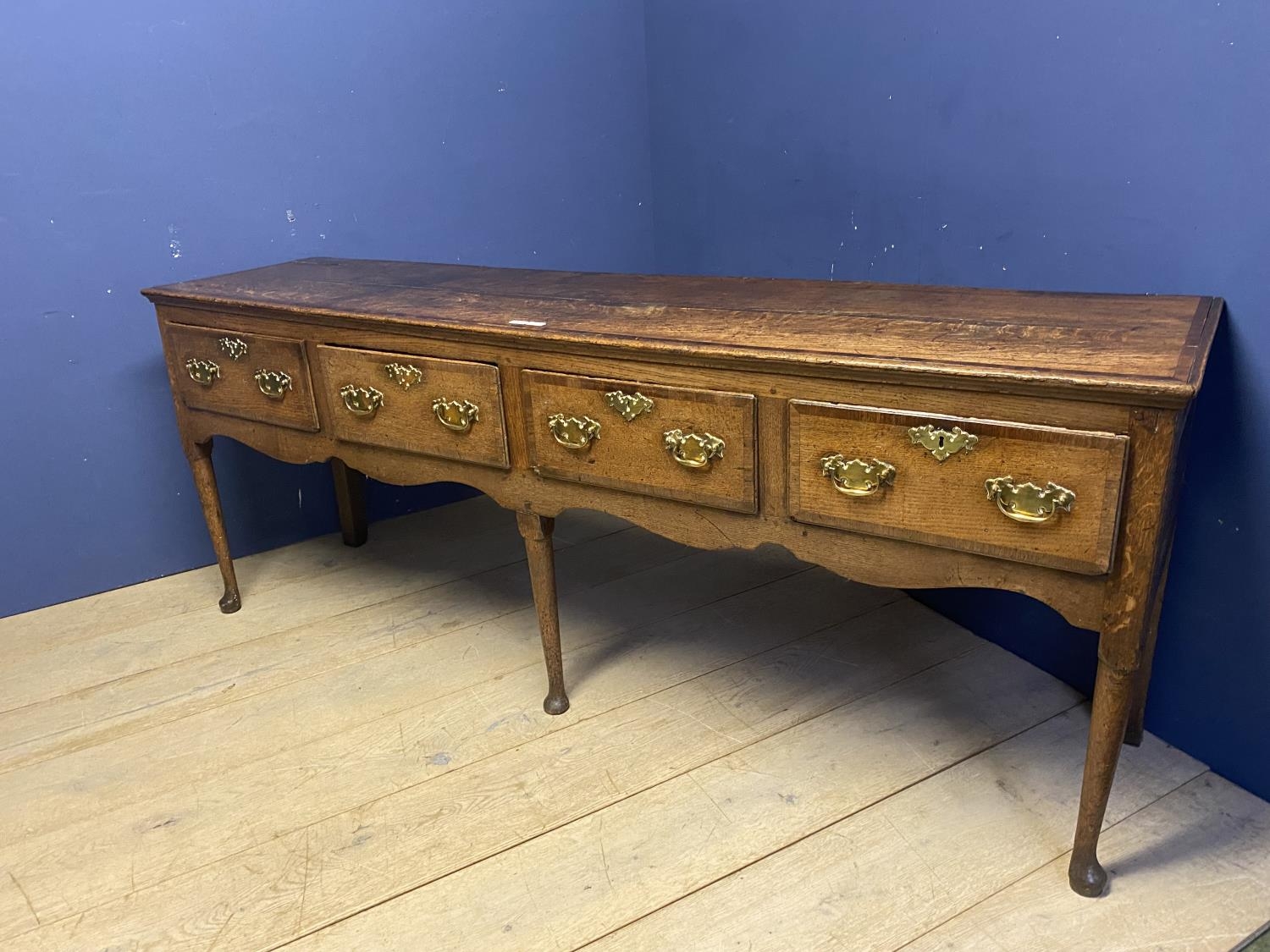 A good oak dresser base, with four drawers and brass handles, 216 x 51cm, some wear and old splits