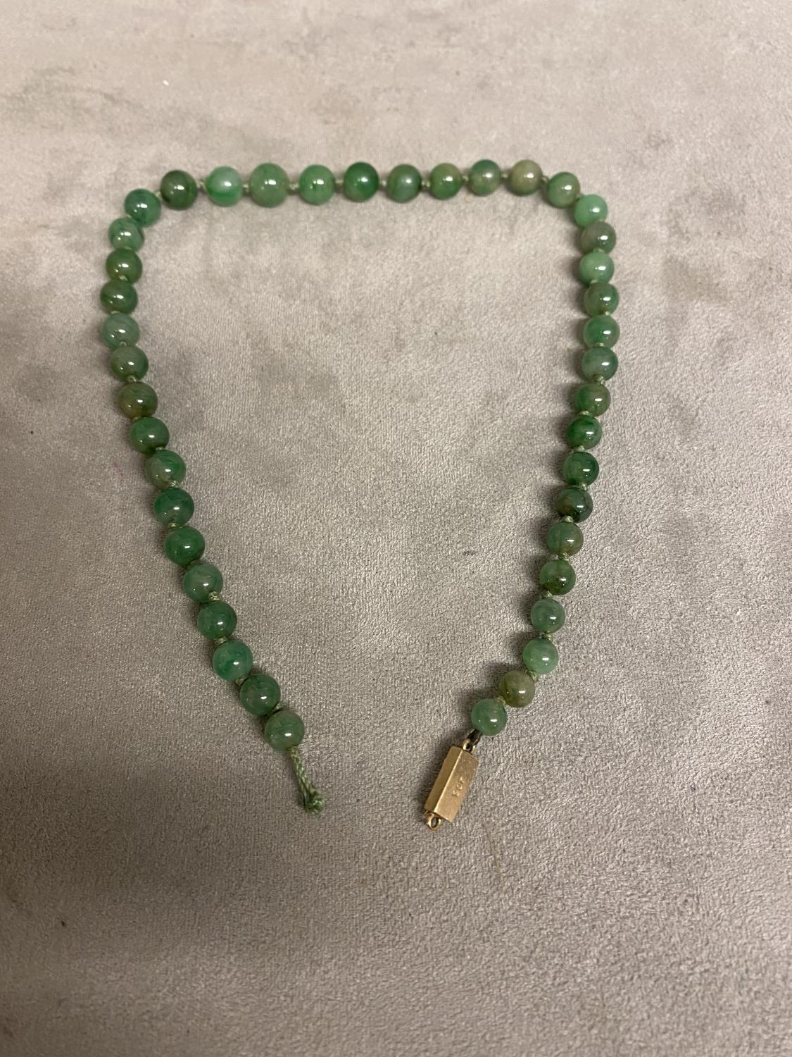 A graduated jade bead necklace on a 9ct gold clasp, 39cm, Largest bead approx 9mm, 33.3g