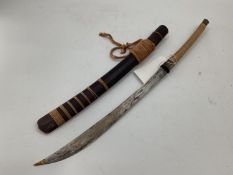 A South Asian machete sword, rattan and brass bound handle, curved blade, wooden scabbard, 75cm