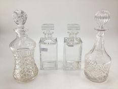 A pair of glass decanters, square stoppers and a star cut bases together with two other glass