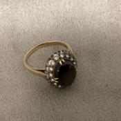 An 18ct gold black star sapphire and diamond ring, central oval cabochon cut sapphire with strong