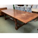 A large heavy oak extending dining table, with solid stretcher to base, 307cm with both ends.