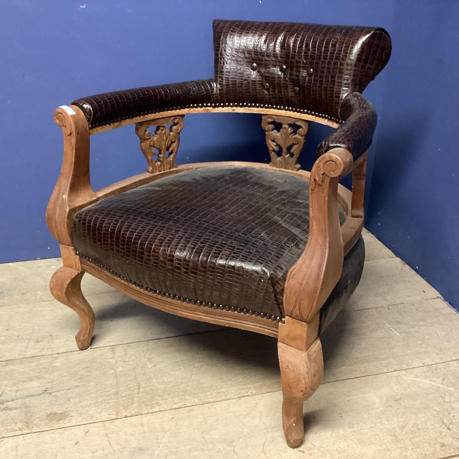 An early C20th walnut tub chair with faux crocodile skin upholstery, 74cmH