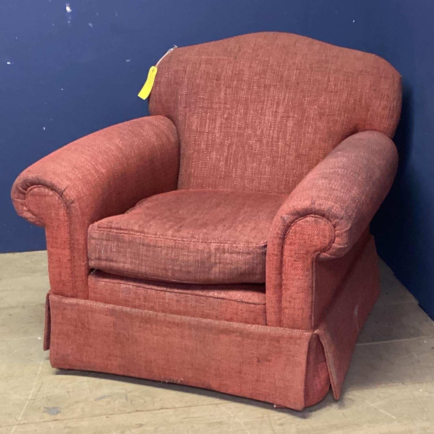 A large deep armchair, upholstered in a deep red fabric, some minor wear with use