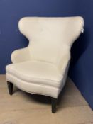 An oversized modern wing backed arm chair, upholstered in cream fabric and brass studded , 120cm H