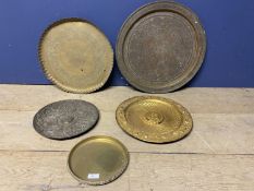 Five metalwares platters, some embossed and carved to centre and rim