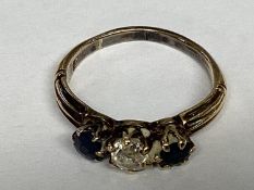 A sapphire and diamond ring in unmarked yellow metal central old diamond, with round cut sapphire