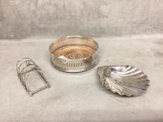 A collection of sterling silver items to include scallop dish, toast rack and wine coaster