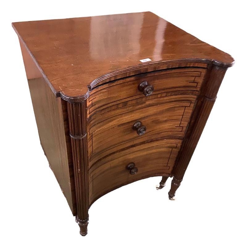 A large Regency mahogany inverted bow front commode with reeded columns and turned raised legs to