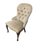 A modern neutral upholstered button back chair