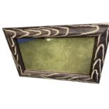 A decorative rectangular wall mirror, framed in a faux chenille brown and cream animal skin border