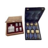 A boxed set of six chased metal wine goblets together with a boxed decanter and four cups by Achen