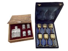 A boxed set of six chased metal wine goblets together with a boxed decanter and four cups by Achen