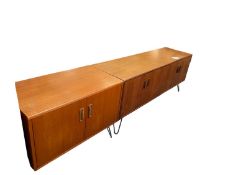 Pair of retro ercol /gplan style two door low cabinet raised on metal legs, and another with a