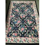 A needlepoint rug, of dark ground and all over rose pattern, 2.74 x 1.83, bears label Needlepoint,