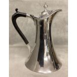 A sterling silver lidded jug on flared circular base