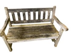 Two seater weathered garden bench, with a galleried ladder back