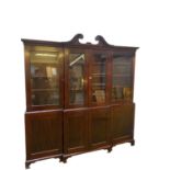 A large late C19th mahogany three sectioned glazed library bookcase, the top with swan neck