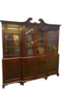 A large late C19th mahogany three sectioned glazed library bookcase, the top with swan neck