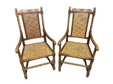 A pair of oak rustic country armchairs, with bergere seat and back, and turned columns and