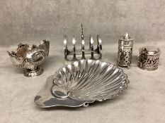 A collection of Sterling silver items to include a scallop dish, toast rack, condiments, various