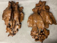 A pair of carved wooden wall sconces , each depicting a pair of game birds on an oak branch, each