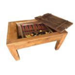 A rustic low table, with inset top and lid opening to reveal a games table and counters 74cm W x